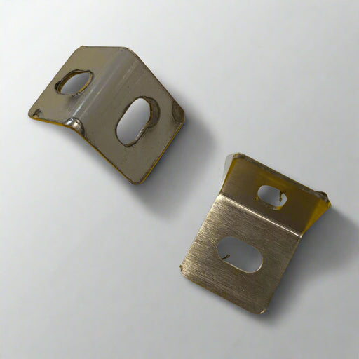 Two metal brackets on a yellow surface