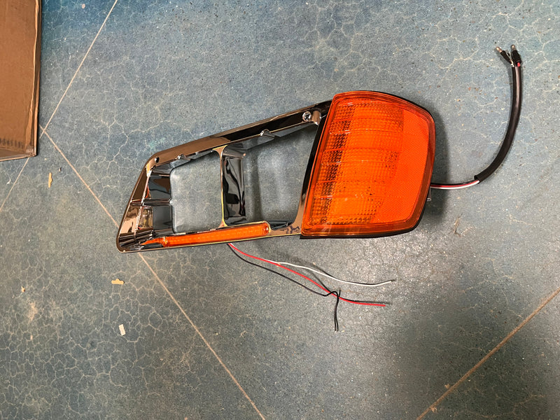 Freightliner FLD 120 chrome plastic headlight bezel with LED turn signal light
