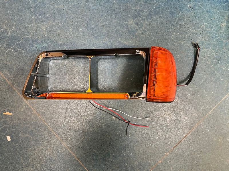 Freightliner FLD 120 chrome plastic headlight bezel with LED turn signal light